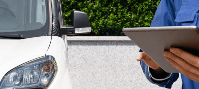 person filling out motor vehicle report next to vehicle