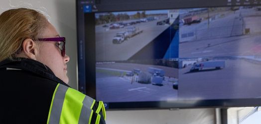 Security guard looking at TV that has surveillance footage