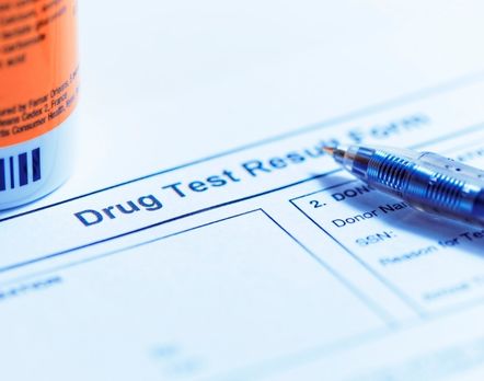 drug test tube, paperwork and pen