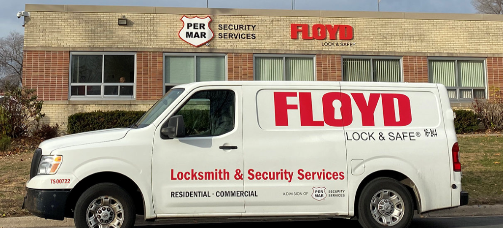 A white van that says Floyd in front of a building that says Per Mar Security Services and Floyd