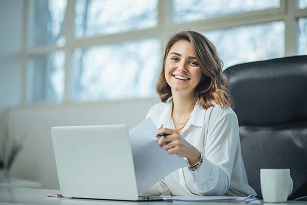 Woman smiling while working at laptop