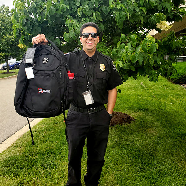 Per Mar Security employee in uniform with labeled backpack