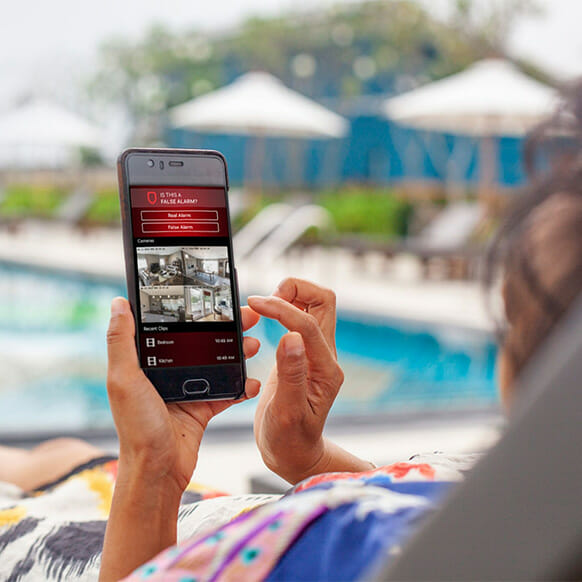 Woman using Per Mar Security app by a pool